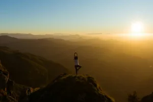woman stretching on mountain top during sunrise from US Yoga Vacation